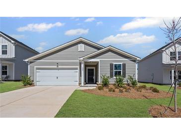 Charming single-story home showcasing a manicured lawn and attached garage on a sunny day at 3087 Birdsong Ave, Covington, GA 30016