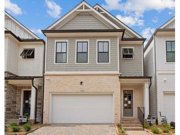 Charming two-story home featuring a brick and gray shake facade with a two-car garage and attractive landscaping at 738 Stickley Oak Way, Woodstock, GA 30189