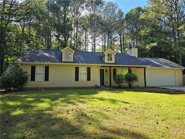 Charming single-story home with a well-manicured lawn and attached two-car garage at 115 Bond Dr, Ellenwood, GA 30294