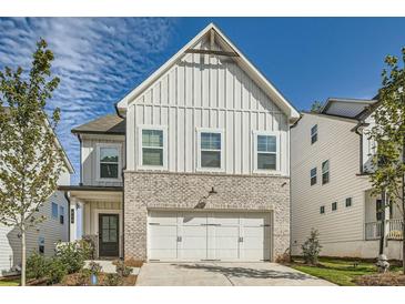 Charming two-story home featuring white siding, brick accents, and an attached two-car garage at 640 Avondale Park Cir, Decatur, GA 30032