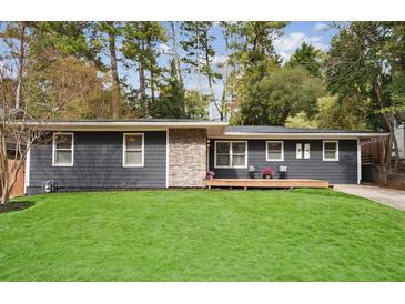 Charming ranch home with gray siding, stone accents, and a spacious lawn at 956 Cardova Dr, Atlanta, GA 30324