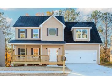 Two-story house with tan siding, dark roof, and a front porch at 6478 Beaver Creek Trl, Atlanta, GA 30349