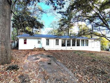 Charming single story home featuring a white exterior, a blue door, and multiple windows with a long driveway at 5928 Dogwood Se Dr, Acworth, GA 30102