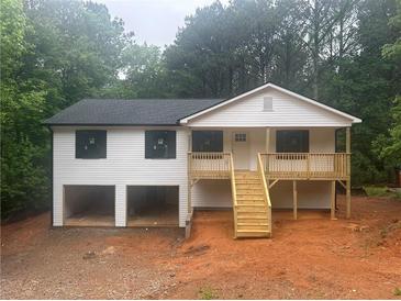 Charming home featuring a two-car garage, white siding, and a welcoming front porch with wooden stairs at 22 High Pointe Dr, White, GA 30184