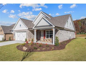 Brick home with craftsman style, 2-car garage, and landscaped yard at 2760 Marie Way, Cumming, GA 30028