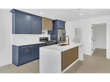 Modern kitchen boasts navy cabinets, a white countertop island with gold accents, and stainless steel appliances at 2067 Arlington Nw Cir, Atlanta, GA 30318