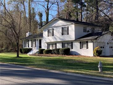 Charming two-story home with manicured lawn, black shutters, and attached two-car garage at 1236 Country Pine Dr, Ellenwood, GA 30294