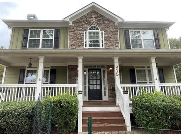 Charming two-story home featuring a stone accent, a welcoming front porch, and lush landscaping at 815 Sylvan Dr, Marietta, GA 30066