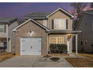 Charming two-story home with brick accents, a one-car garage, and well-maintained landscaping at 6427 Grey Fox Way, Riverdale, GA 30296