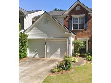 Charming townhouse with brick and siding, featuring a two-car garage and landscaped front yard at 183 Regent Pl, Woodstock, GA 30188