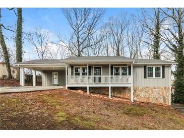 Charming home featuring a quaint front porch, stone accents, and convenient covered parking at 407 Robins Nest Ct, Woodstock, GA 30189
