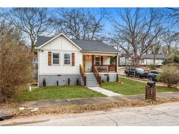 Charming home featuring a yellow front door, quaint porch, and beautiful landscaping at 1375 Miller Reed Se Ave, Atlanta, GA 30315