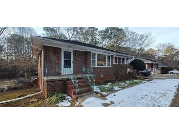 Brick ranch home with steps and small front yard; some snow on the ground at 1181 Rocksprings St, Forest Park, GA 30297