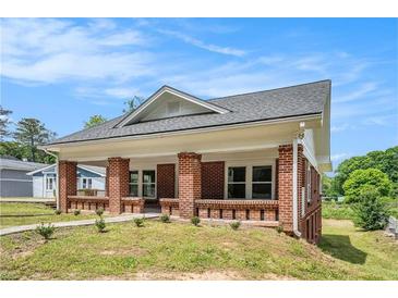 Charming brick home with a covered front porch and freshly landscaped yard at 1220 Hightower Nw Rd, Atlanta, GA 30318