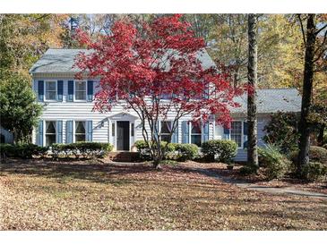 Two-story house with blue shutters, landscaping, and a tree with red leaves at 1111 Valley Ridge Se Ct, Marietta, GA 30067