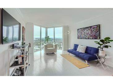 Bright living room boasting floor-to-ceiling windows with city views, modern decor, and sleek hardwood floors at 2870 Pharr Court S Nw # 2703, Atlanta, GA 30305