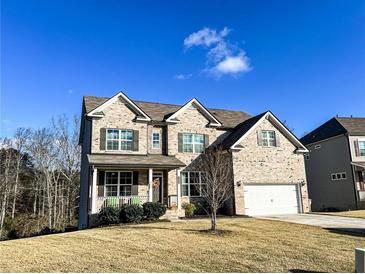 Two-story brick home with a large front yard and attached garage at 7860 Bristol Valley Dr, Cumming, GA 30028