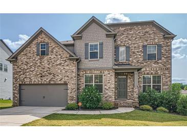 Charming two-story brick home with well-maintained lawn, two car garage, and professionally landscaped front yard at 207 Eagles Flight, Villa Rica, GA 30180