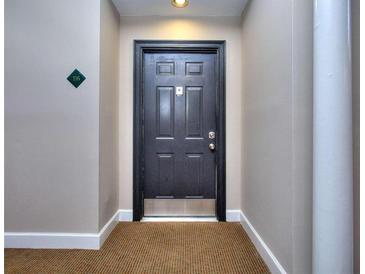 Neutral hallway featuring a solid dark-colored entry door and apartment number at 240 Renaissance Pkwy # 116, Atlanta, GA 30308