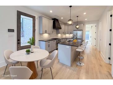 Bright, modern kitchen featuring stainless steel appliances, a large island, and a dining area with stylish chairs at 290 2Nd St, Fayetteville, GA 30214