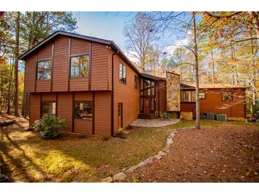 Beautiful brown two-story home with stone accents and lots of windows surrounded by colorful trees at 4771 Cool Springs Rd, Winston, GA 30187