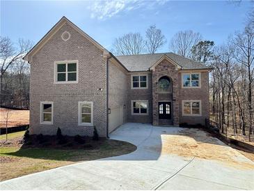 Stunning two-story brick home featuring a stone archway entrance and an attached garage on a spacious lot at 4251 Matisse Ln, Fairburn, GA 30213