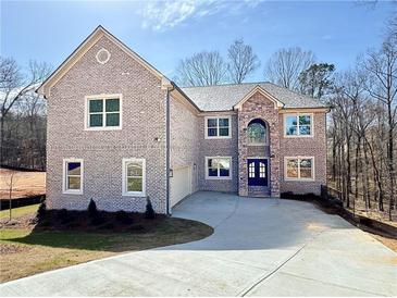 Charming two-story brick home featuring a manicured lawn and a spacious driveway, offering a welcoming curb appeal at 4251 Matisse Ln, Fairburn, GA 30213