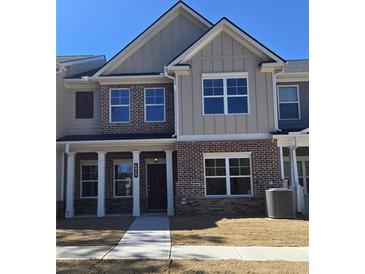 Charming two-story townhome featuring a brick facade, covered porch, and well-lit windows at 4849 Walkers Green, Mableton, GA 30126