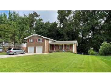 Charming two-story brick home featuring a well-manicured front lawn and a two-car garage at 2071 Carthage Rd, Tucker, GA 30084