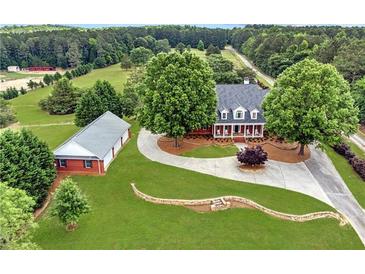 Aerial view of a two-story home, detached garage, and expansive lawn at 2054 Cook Rd, Oxford, GA 30054