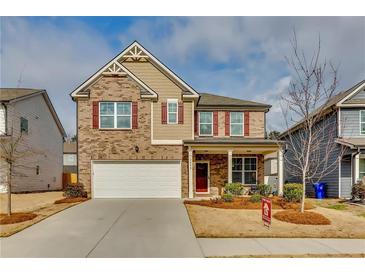 Charming two-story home with brick and siding, a well-manicured lawn, and a two-car garage at 7214 Gladstone Cir, Stonecrest, GA 30038