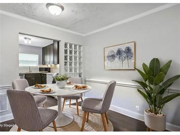 Cozy dining area features a round table with seating for four, adjacent to an open kitchen and a decorative plant at 5566 Kingsport Dr, Atlanta, GA 30342