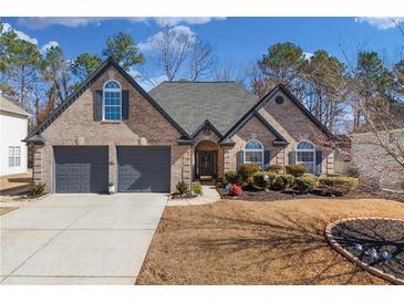 Charming brick home featuring a two-car garage and a well-manicured front yard at 374 Cherington Ln, Lawrenceville, GA 30044