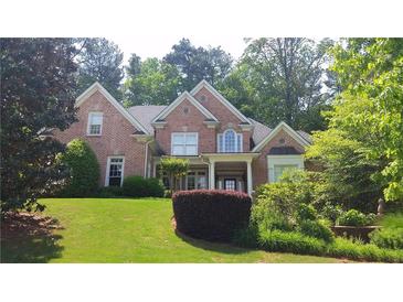 Charming brick home featuring a well-manicured lawn and mature trees at 2883 Thurleston Ln, Duluth, GA 30097
