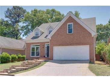 Brick two-story house with a white garage door and stone steps leading to the entrance at 4083 Brookside Manor Dr, Tucker, GA 30084