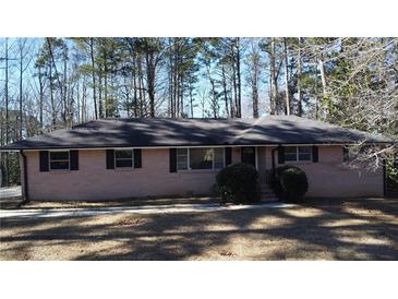 Single-story brick home featuring dark shutters, a dark roof, and manicured landscaping at 3685 Emily Way, Atlanta, GA 30349