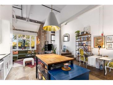 Inviting living room featuring exposed brick, large windows, and stylish furnishings at 978 North Ne Ave # 107, Atlanta, GA 30306