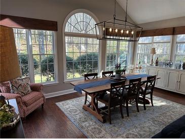 Sun-drenched dining room features a rustic farmhouse table and ample natural light at 1025 Charleston Trce, Roswell, GA 30075