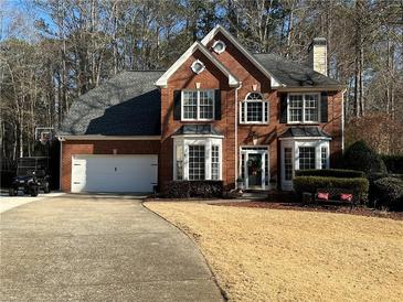 Brick house with a two-car garage and landscaped yard at 1025 Charleston Trce, Roswell, GA 30075