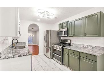 A spacious kitchen features sleek, stainless steel appliances and granite countertops, offering a modern and functional design at 6323 Wedgeview Dr, Tucker, GA 30084