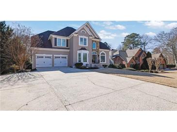 Stately two-story home with a manicured lawn, three-car garage, and a beautiful stone and stucco facade at 6705 Brookline Ct, Cumming, GA 30040