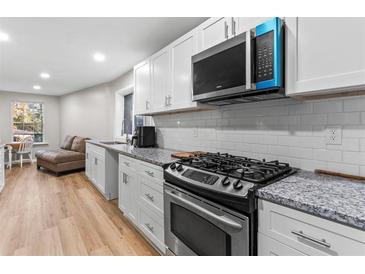 Modern kitchen features granite countertops, stainless steel appliances, and white shaker cabinets at 3189 Bellgreen Way, Decatur, GA 30032