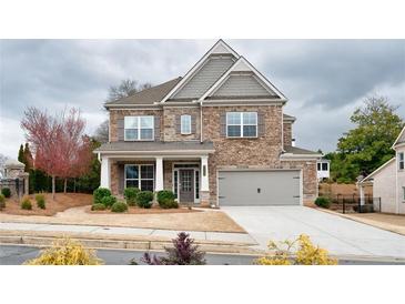 Beautiful two-story brick home featuring a covered porch and attached two-car garage at 5133 Greenard Watson Lane, Buford, GA 30518