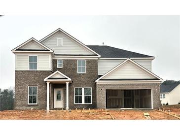 Two-story house with gray brick and beige siding, a three-car garage, and a covered entryway at 3121 Morris Hills Dr, Dacula, GA 30019