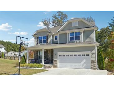 Charming two-story home featuring a front porch, attached garage, and a well-manicured lawn at 2599 Windsor Knoll Dr, Dacula, GA 30019