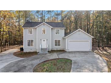 Two-story house with gray siding, attached garage, and a paved driveway at 1238 Sandy Creek Rd, Fayetteville, GA 30214