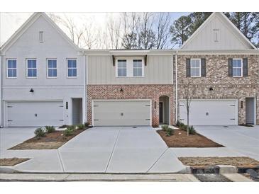 Charming townhome exteriors showcasing varied brick and siding facades, complemented by well-manicured landscaping at 693 Sunstone Ln, Lawrenceville, GA 30043