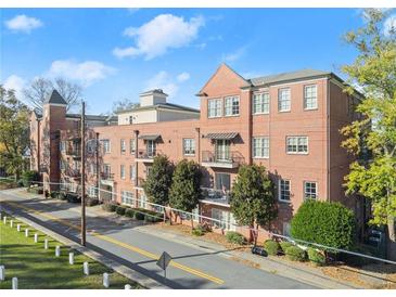 Beautiful brick building featuring manicured landscaping, balconies, and awning covered front doors at 351 Washington Ne Ave # 302, Marietta, GA 30060