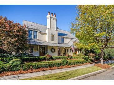 Two-story house with metal roof, landscaped yard, and large front porch at 6715 Berkley Rd, Cumming, GA 30040