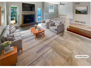 Bright living room with fireplace, plush seating, and large windows providing abundant natural light at 2007 Variations Ne Dr, Atlanta, GA 30329